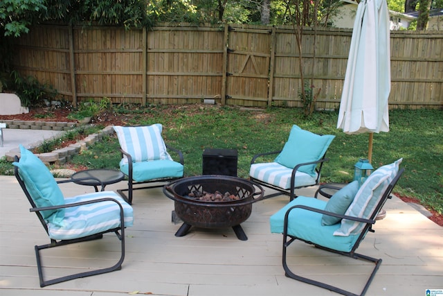 view of patio / terrace with an outdoor fire pit, a deck, and fence