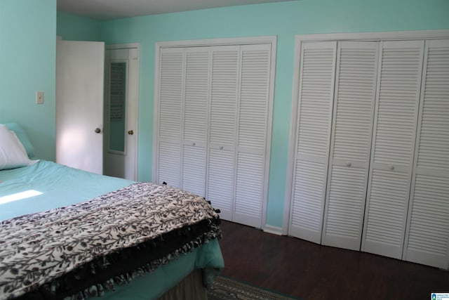 bedroom featuring dark wood finished floors and multiple closets