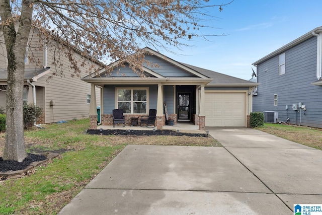 view of front of property with brick siding, central air condition unit, covered porch, driveway, and an attached garage