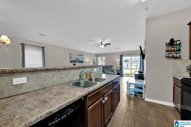 kitchen featuring visible vents, a sink, black appliances, tasteful backsplash, and open floor plan