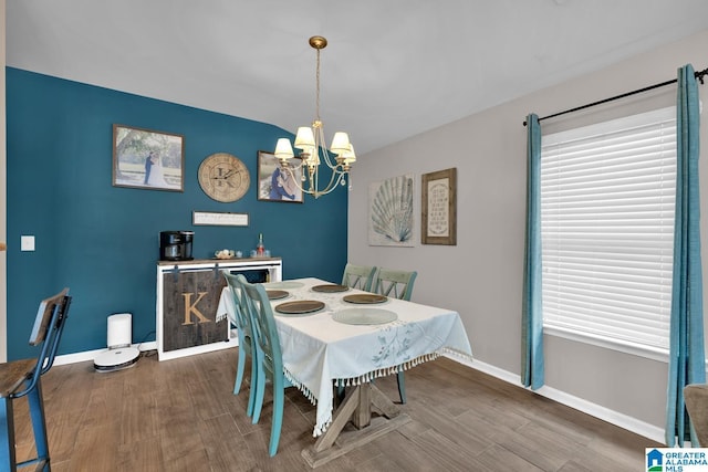 dining space with a chandelier, baseboards, and wood finished floors