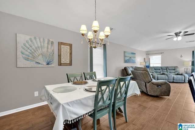 dining room with visible vents, baseboards, wood finished floors, and ceiling fan with notable chandelier