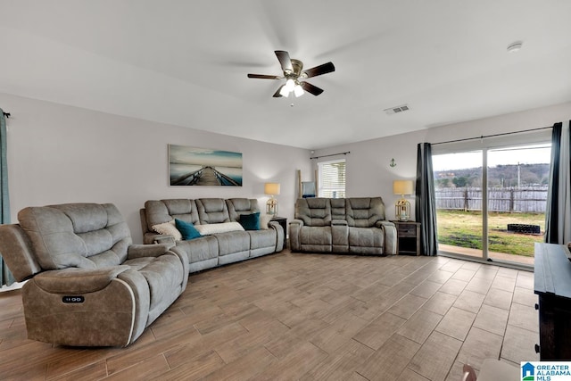 living room with visible vents, plenty of natural light, light wood-style flooring, and ceiling fan