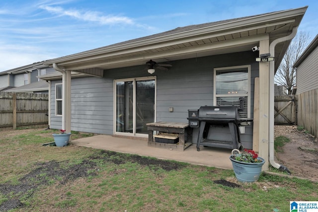 rear view of house with a ceiling fan, a patio, a fenced backyard, and a lawn