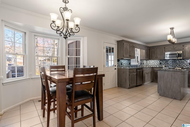 dining area featuring light tile patterned floors, an inviting chandelier, and ornamental molding