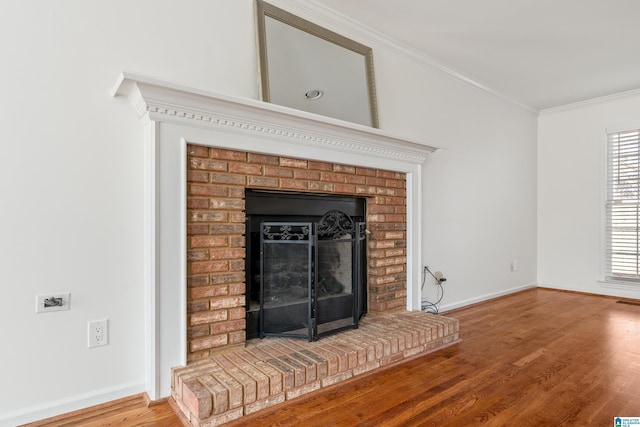 details featuring baseboards, wood finished floors, ornamental molding, and a fireplace