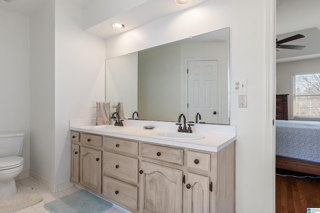 full bathroom with toilet, connected bathroom, tile patterned flooring, and a sink