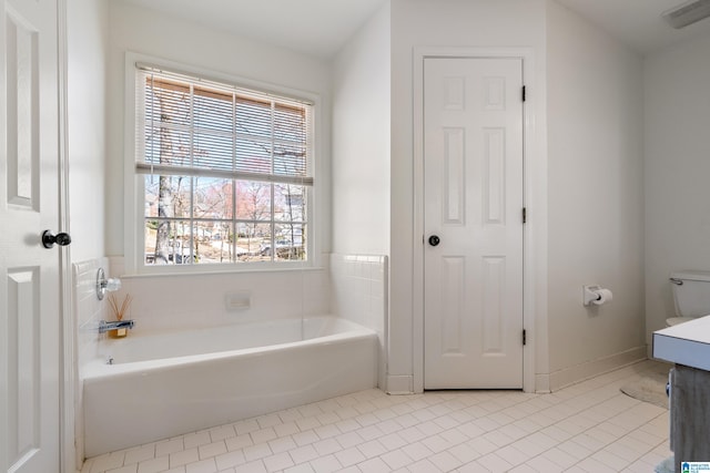 bathroom featuring tile patterned floors, visible vents, and a bath