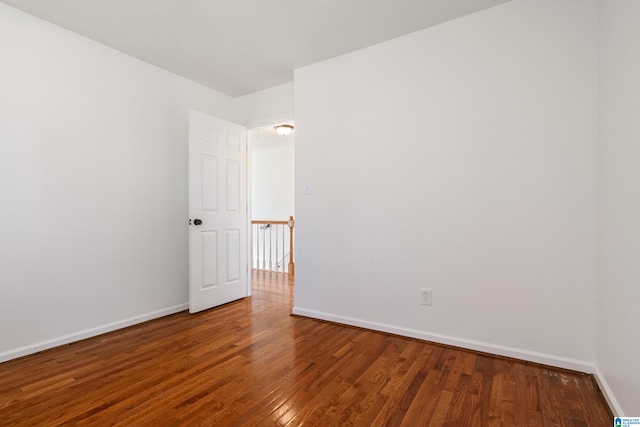 unfurnished room featuring baseboards and wood-type flooring