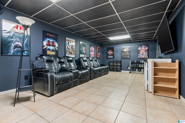 home theater featuring tile patterned floors, a drop ceiling, and baseboards