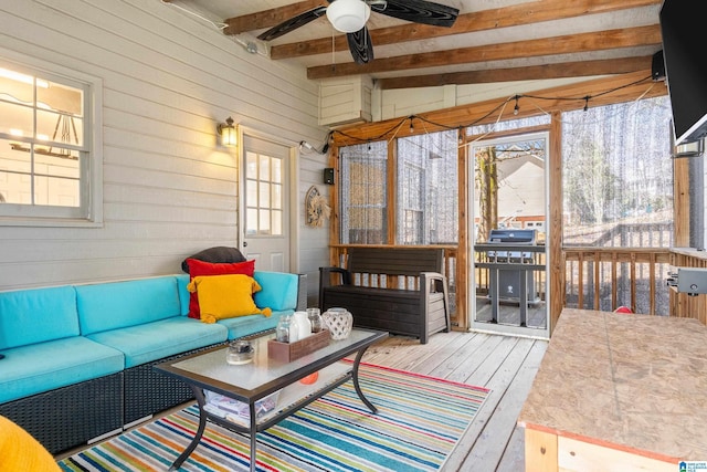 sunroom with lofted ceiling with beams and a ceiling fan