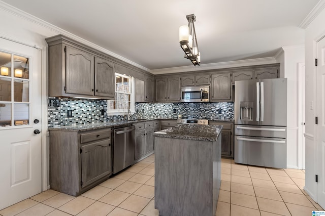 kitchen with light tile patterned floors, appliances with stainless steel finishes, and ornamental molding