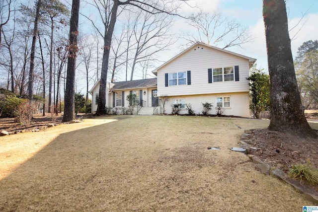 split level home with brick siding and a front lawn