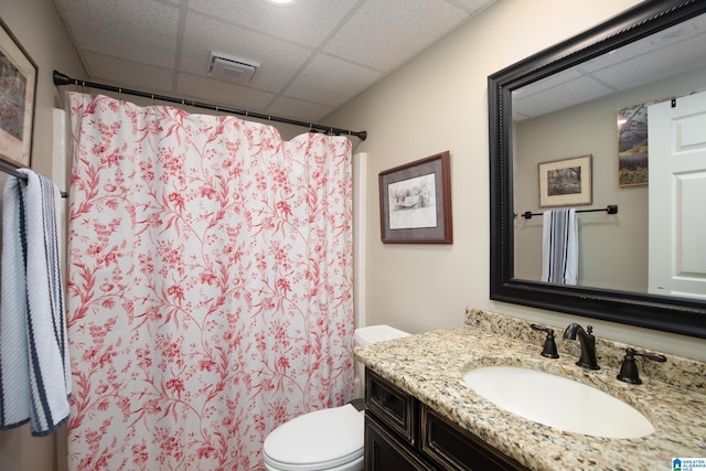 full bath with vanity, curtained shower, toilet, and a drop ceiling