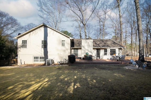 back of property with brick siding, central AC, a lawn, a deck, and outdoor dining space