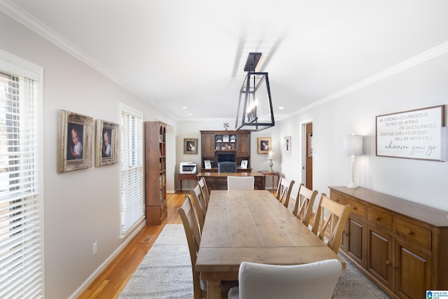 dining space with baseboards, light wood-style floors, and crown molding