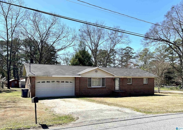 single story home featuring a front lawn, an attached garage, brick siding, and driveway