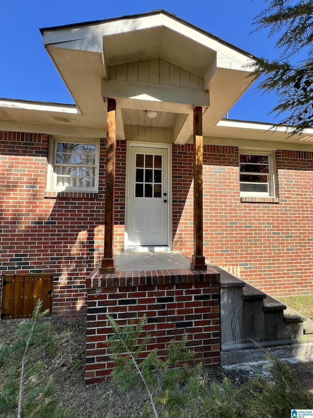 doorway to property featuring brick siding