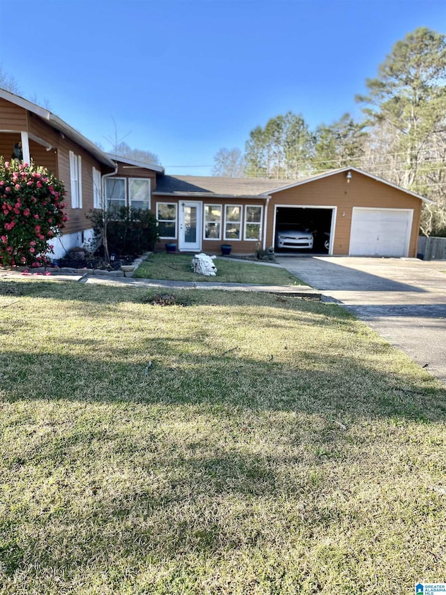 single story home featuring a front yard and a detached garage