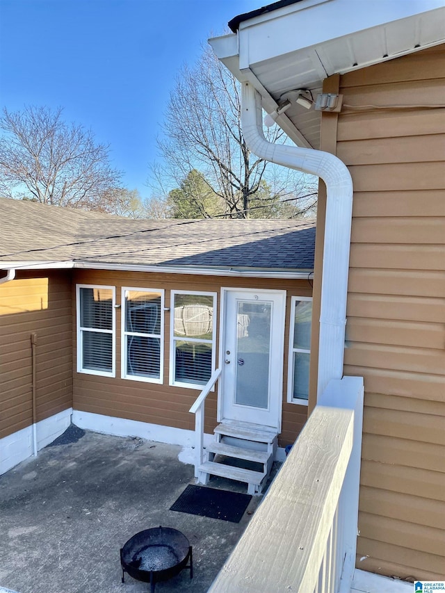 property entrance featuring roof with shingles