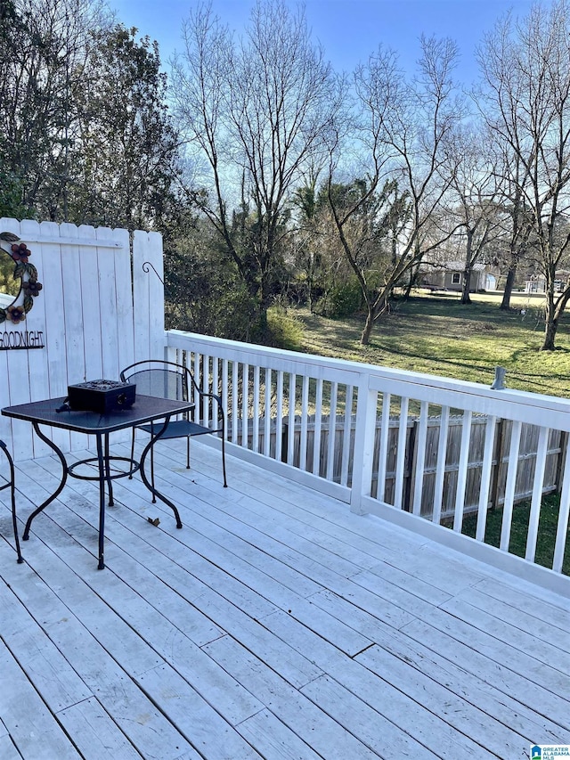 wooden terrace featuring a lawn