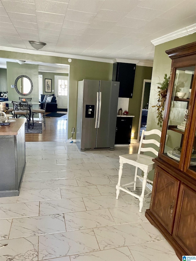 kitchen with marble finish floor, ornamental molding, and stainless steel refrigerator with ice dispenser