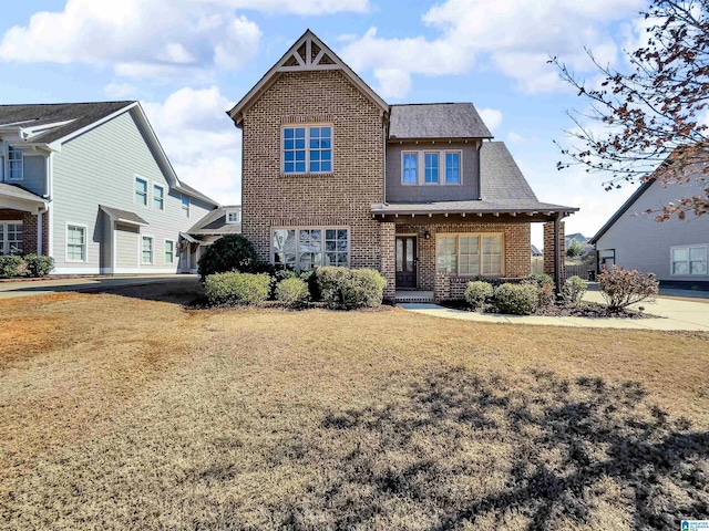 view of front of property featuring brick siding and a yard