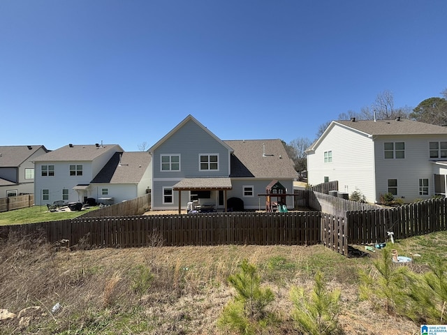 rear view of property featuring a residential view and a fenced backyard