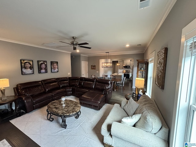 living area with visible vents, crown molding, a ceiling fan, and wood finished floors