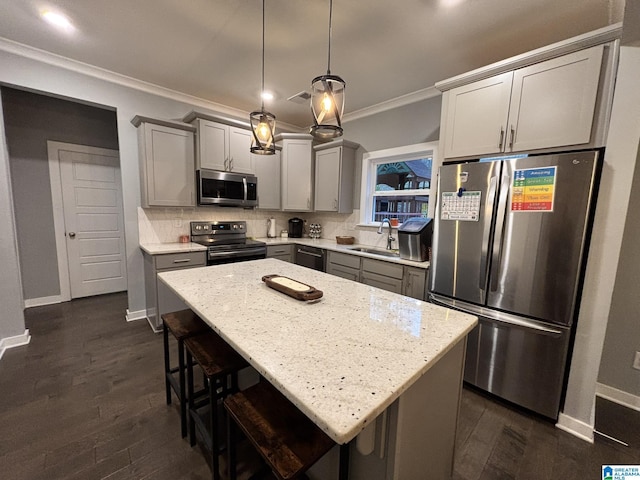 kitchen with ornamental molding, gray cabinets, a sink, backsplash, and stainless steel appliances