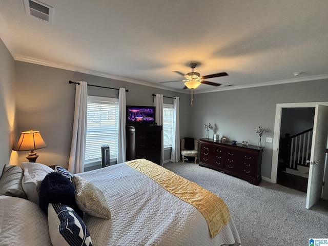 bedroom with carpet flooring, a ceiling fan, visible vents, and ornamental molding