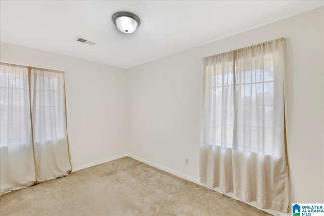 carpeted spare room with baseboards and visible vents