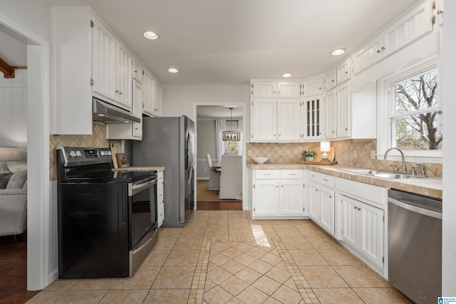 kitchen featuring light tile patterned floors, a sink, stainless steel appliances, light countertops, and under cabinet range hood