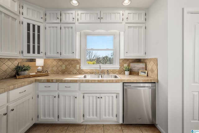 kitchen featuring a sink, stainless steel dishwasher, white cabinets, and light countertops