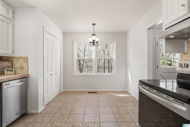 kitchen featuring light tile patterned floors, stainless steel appliances, tasteful backsplash, and an inviting chandelier