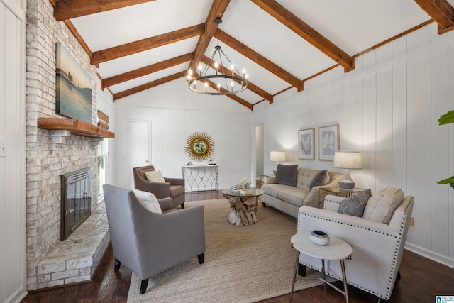 living room with a brick fireplace, vaulted ceiling with beams, an inviting chandelier, and wood finished floors