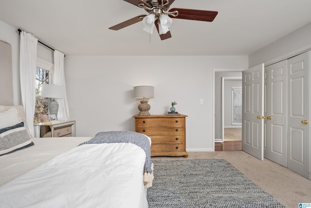 bedroom featuring baseboards, carpet floors, a closet, and a ceiling fan