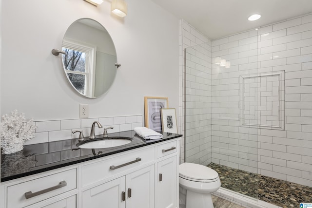 full bathroom featuring tiled shower, recessed lighting, toilet, and vanity