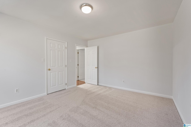 unfurnished room featuring carpet flooring and baseboards