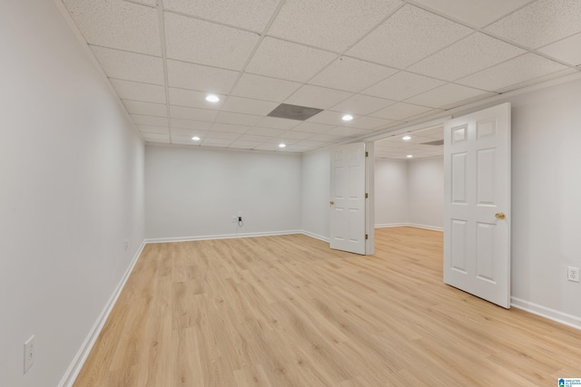 finished below grade area featuring a drop ceiling, recessed lighting, light wood-type flooring, and baseboards