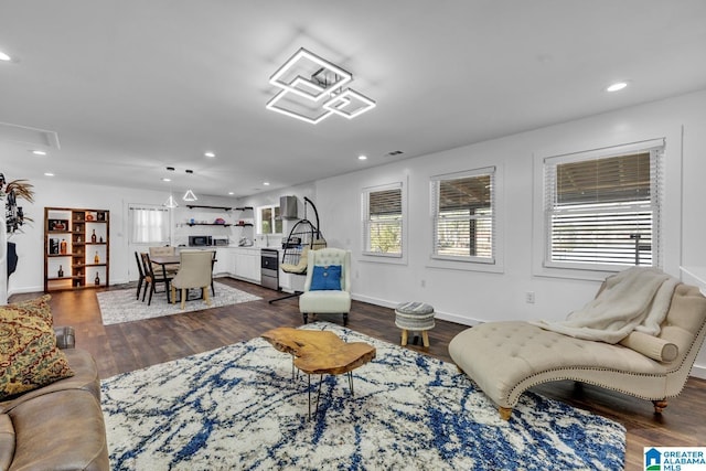 living area featuring recessed lighting, dark wood-style flooring, and baseboards