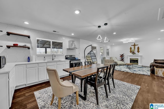 dining area featuring recessed lighting, dark wood-style flooring, and a fireplace