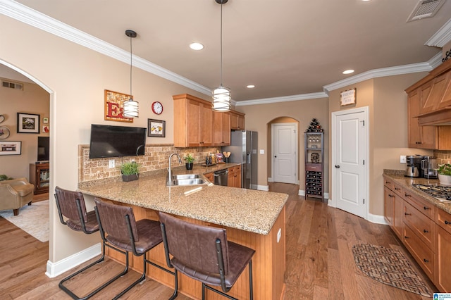 kitchen featuring a sink, stainless steel appliances, arched walkways, and visible vents