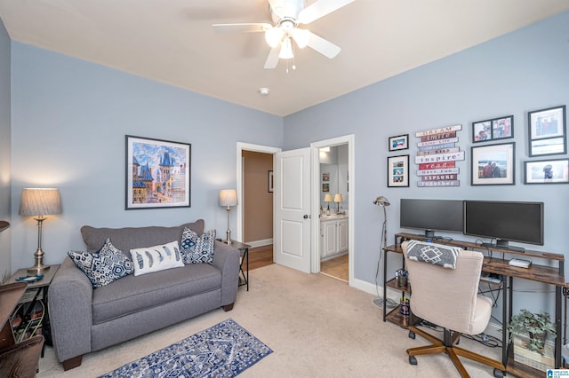 office area with a ceiling fan, light colored carpet, and baseboards