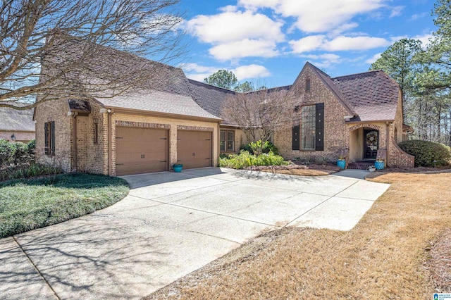 view of front of property featuring a garage, brick siding, driveway, and a shingled roof