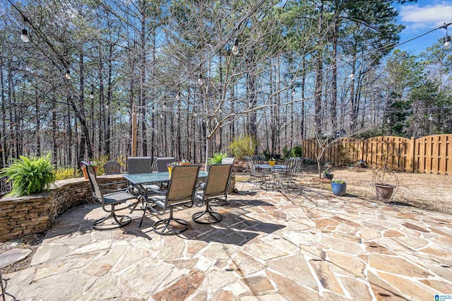 view of patio with outdoor dining space and fence