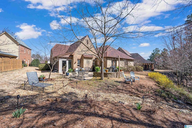 back of property with a patio area and fence