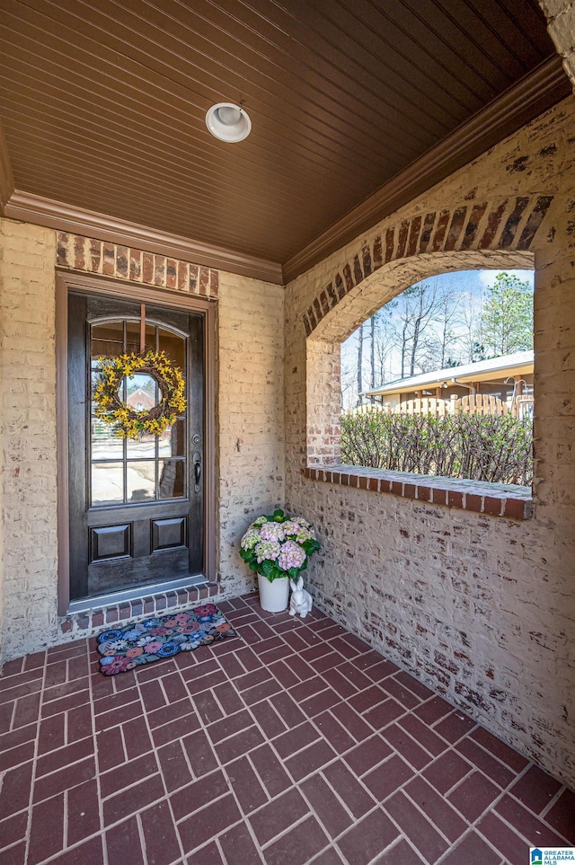 property entrance with brick siding and covered porch