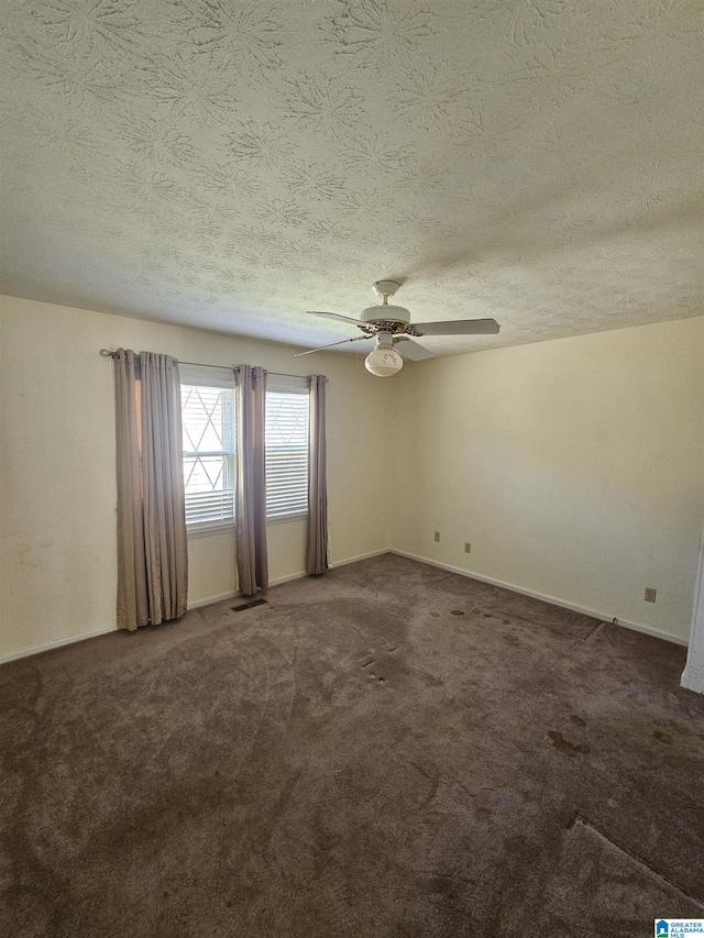 carpeted empty room featuring a textured ceiling, baseboards, and a ceiling fan