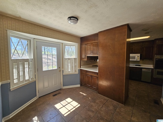 kitchen featuring white microwave, visible vents, plenty of natural light, and light countertops